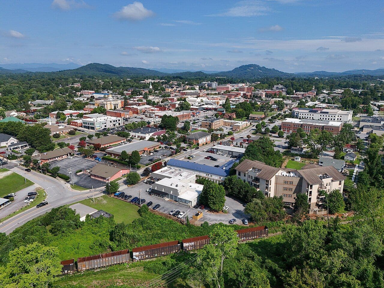 Aerial view of Hendersonville's tree-lined downtown with the Blue Ridge Mountains behind it