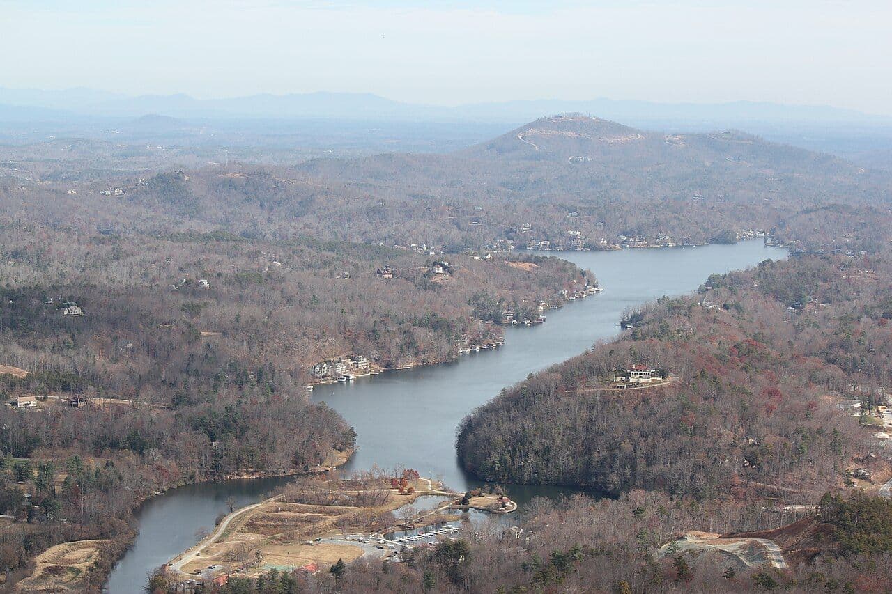Lake Lure winding between forested mountains, seen from high above at Chimney Rock