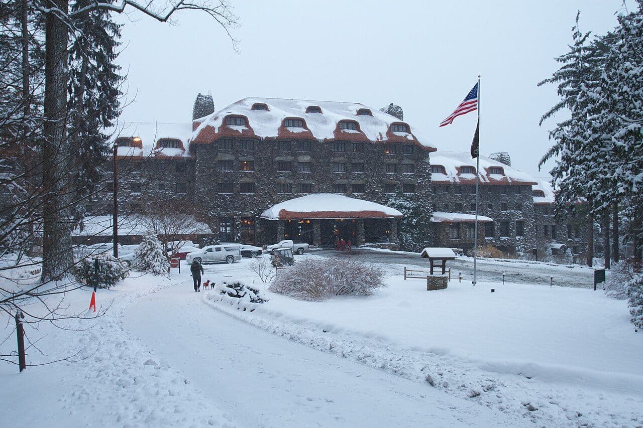 The stone Omni Grove Park Inn with snow covering the grounds, trees and roof