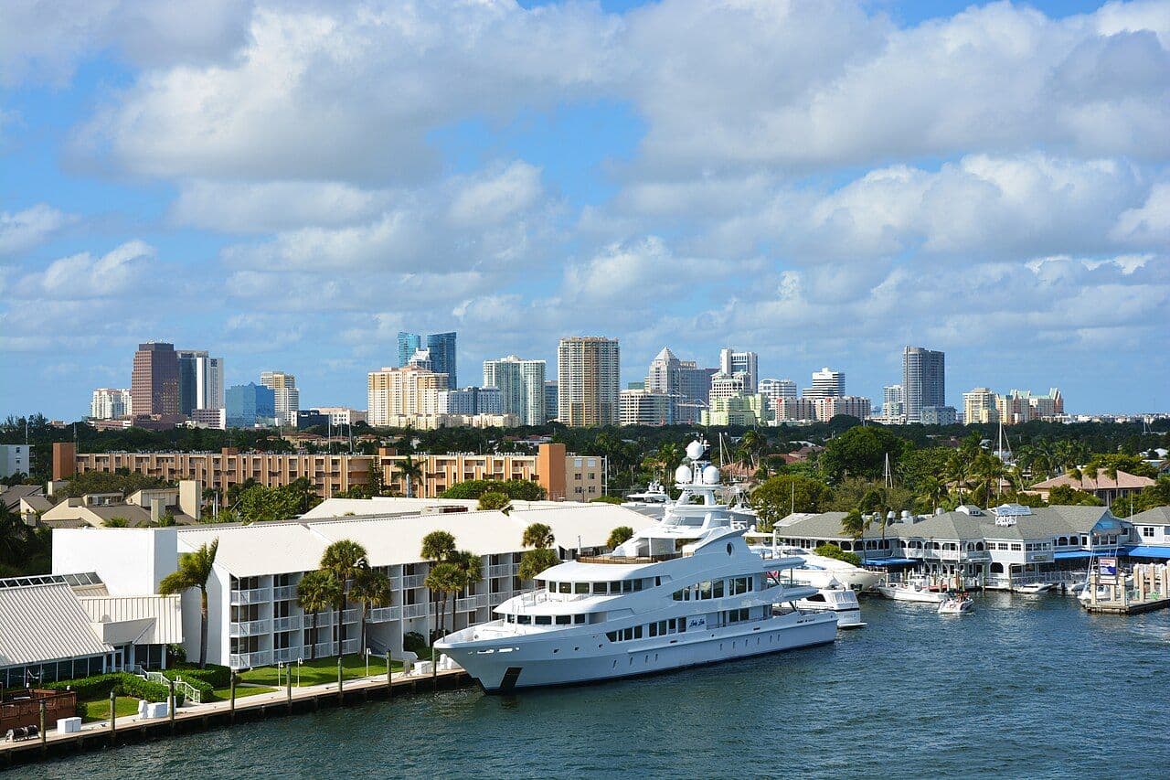 Fort Lauderdale high-rise skyline behind a marina with a large yacht on the water