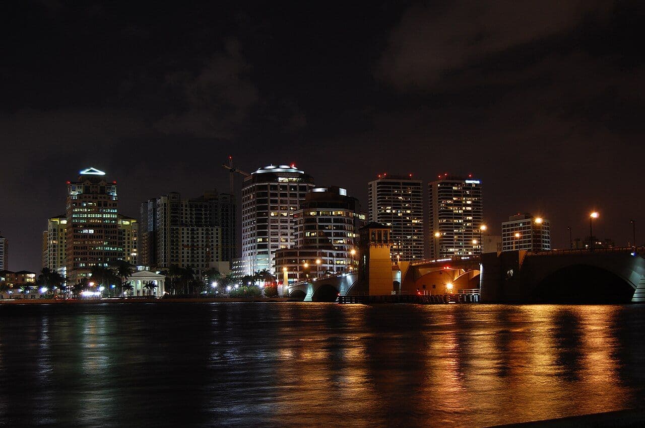 West Palm Beach skyline lit up at night and reflected in the Lake Worth Lagoon