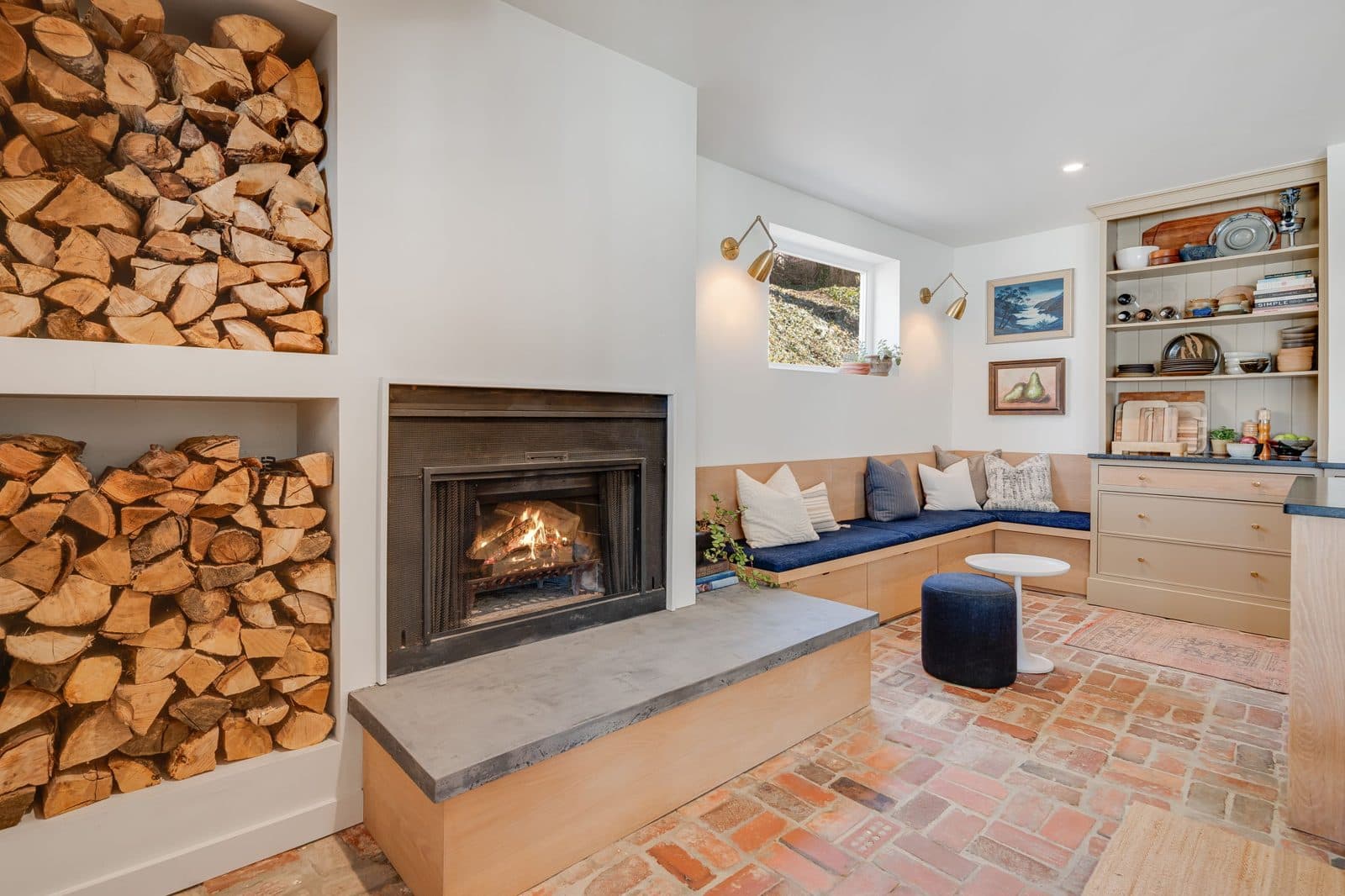 Kitchen sitting area with a wood-burning fireplace insert and floor-to-ceiling firewood storage
