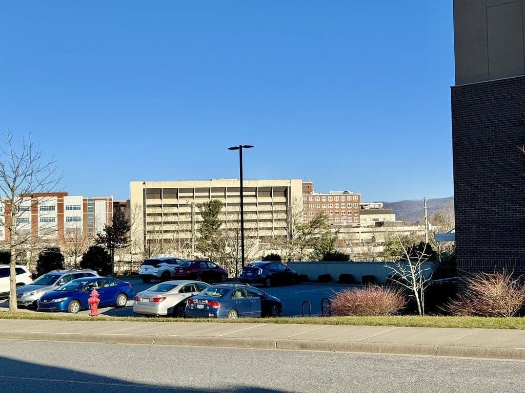 Mission Hospital campus buildings in Asheville seen across a parking lot under a clear blue sky