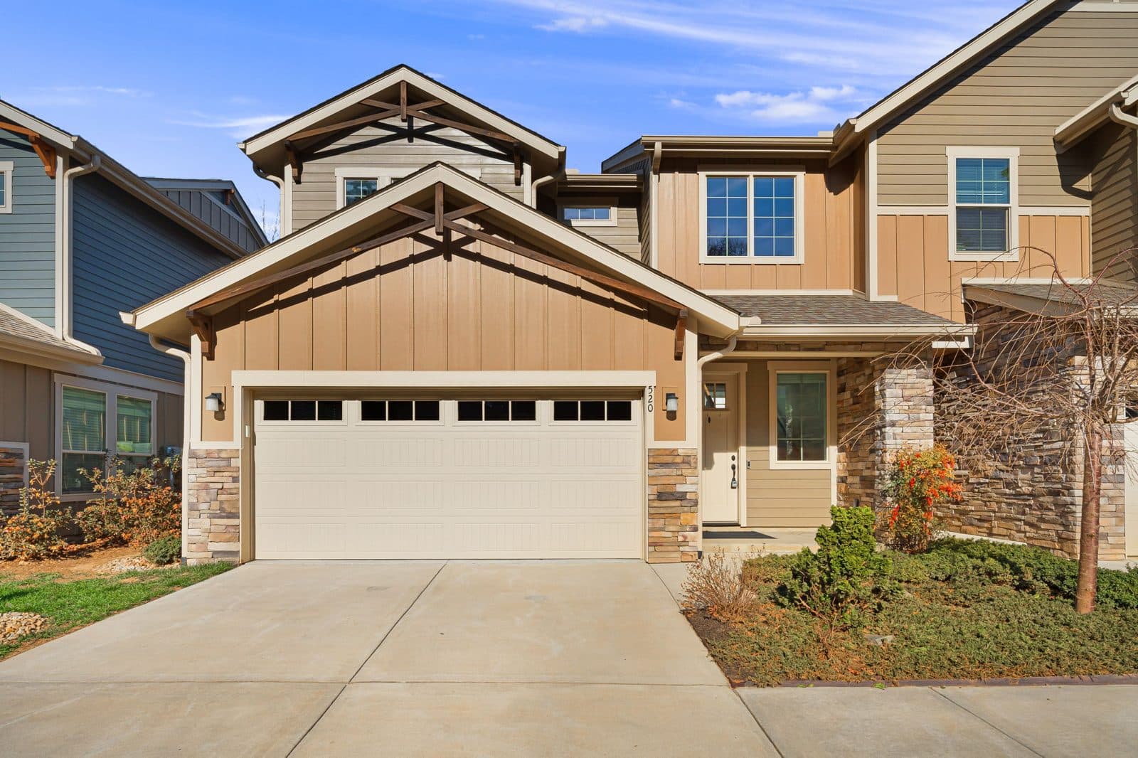 One-level patio home with an attached two-car garage, stone accents and a short flat driveway