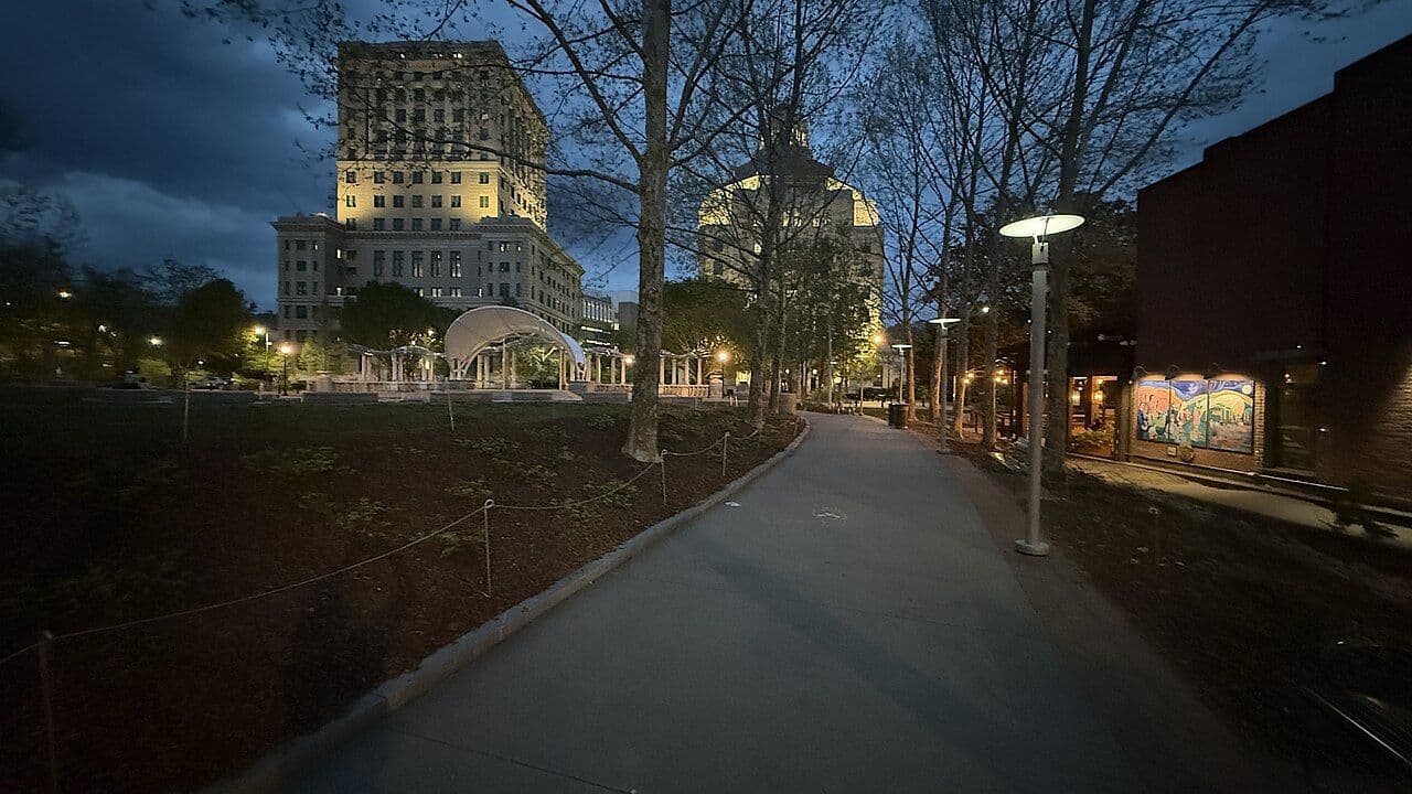 Asheville City Hall's pink art deco dome and the Buncombe County Building lit up at night